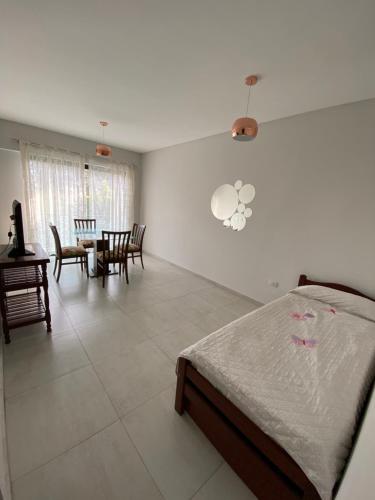 - une chambre avec un lit, une table et des chaises dans l'établissement Family Apart, à San Miguel de Tucumán