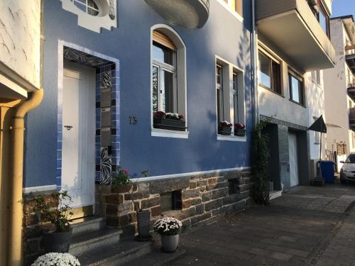 ein blaues Gebäude mit Fenstern und Topfpflanzen darauf in der Unterkunft Ferienwohnung Mosel-Rhein in Koblenz