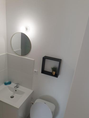 a bathroom with a toilet and a mirror and a sink at Studio 5 Henriville in Amiens