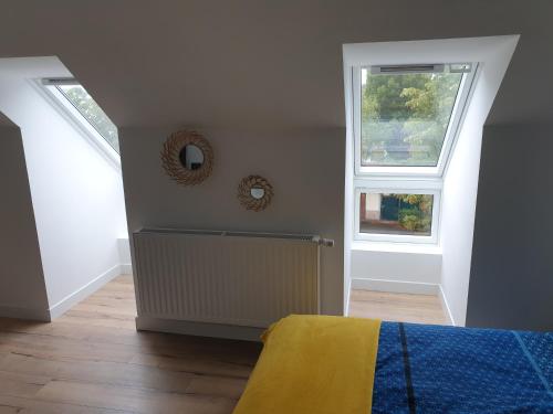 a bedroom with two windows and a bed in it at Studio 5 Henriville in Amiens