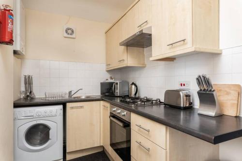 una cucina con lavatrice, piano cottura e lavastoviglie di Cosy Stay Swansea - TV in every bedroom a Swansea