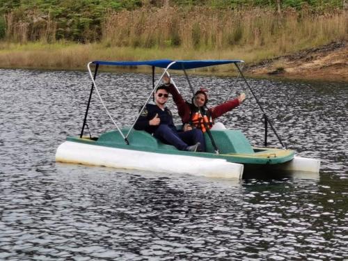 two people sitting on a paddle boat on a lake at Finca Isla El Paraiso in Guatapé