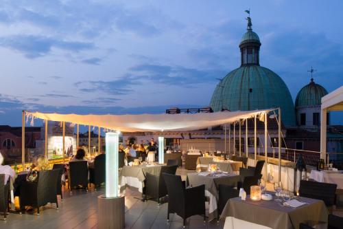 ein Restaurant auf dem Dach eines Gebäudes in der Unterkunft Hotel Carlton On The Grand Canal in Venedig