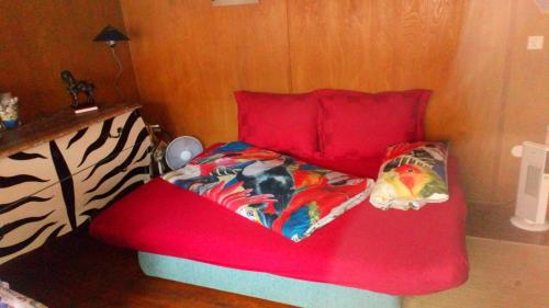 a red couch with a bed in a room at Reitstation Roßmühle in Gräfendorf