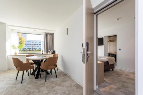a room with a table and chairs and a bedroom at Hotel de Rousch - 4 sterren Superieur in Heerlen