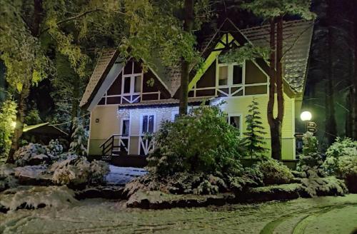 una casa por la noche con luces encendidas en Snezhny Resort, en Korobitsyno