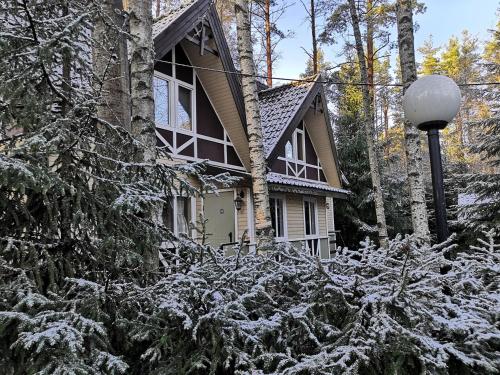 una casa cubierta de nieve delante en Snezhny Resort, en Korobitsyno