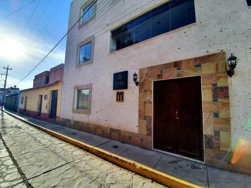 a building with a door on the side of a street at Vita Hoteles Colca in Chivay