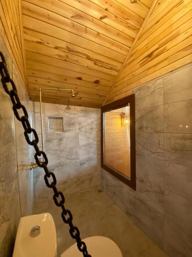 a bathroom with a toilet and a wooden ceiling at Ali's Bungalow in Kaş