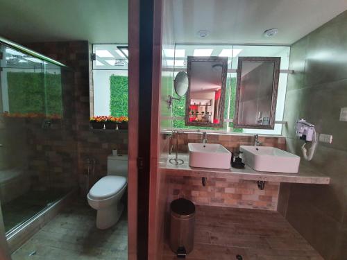 a bathroom with two sinks and a toilet at Vita Hoteles Colca in Chivay