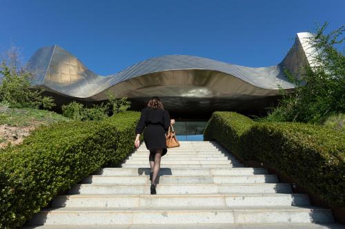 a woman walking up some stairs in front of a building at Vik Chile in San Vicente de Taguatagua