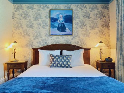 a bedroom with a bed with a blue comforter at Le Chateau de Pierre in Quebec City