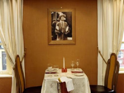 uma sala de jantar com uma mesa e uma imagem na parede em Harty Costello Town House em Ballybunion