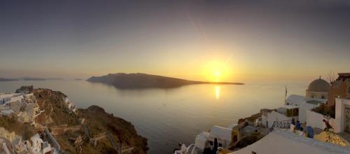 a view of the sun setting over the water at Art Maisons Oia Castle in Oia