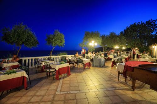 a patio area with tables, chairs and umbrellas at Grand Hotel Le Rocce in Gaeta