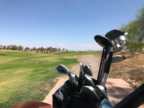 un montón de palos de golf en una bolsa en un campo de golf en Riad Chocolat, en Marrakech