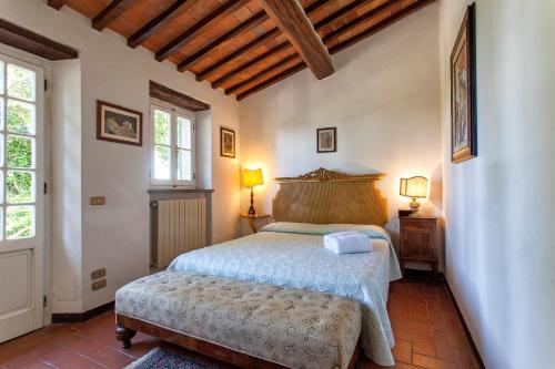 een slaapkamer met een bed en twee ramen en twee lampen bij Villa Serena & Dépendances in Cortona