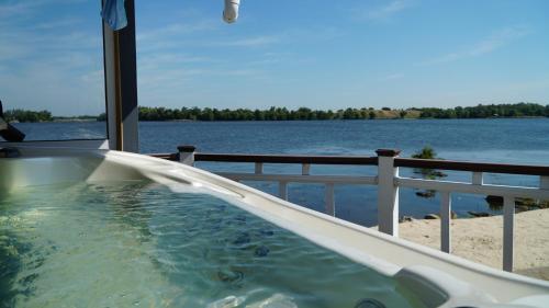 a hot tub on a balcony with a view of the water at Спа-Готель Потоки Хауз in Kam”yani Potoky