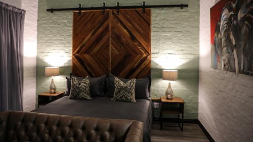 a bedroom with a large bed and a leather couch at Rooiberg Wild Private Game Reserve in Ladismith