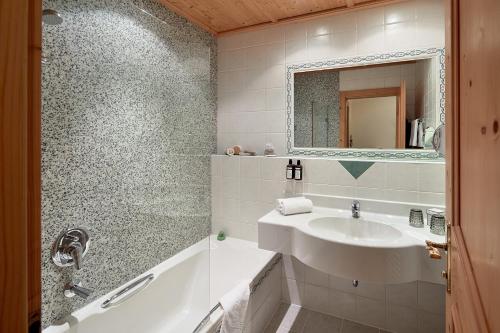 a bathroom with a sink and a mirror at Hotel Central - das kleine Boutique Hotel am Achensee in Pertisau