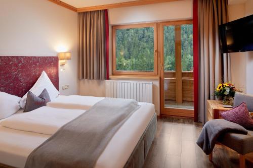 a hotel room with two beds and a window at Hotel Central - das kleine Boutique Hotel am Achensee in Pertisau