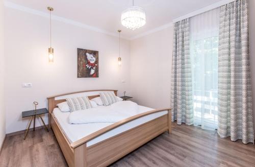 a bedroom with a bed and a large window at Hotel Garni ELISABETH in Pörtschach am Wörthersee