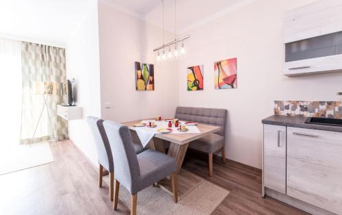 a kitchen with a dining room table and chairs at Hotel Garni ELISABETH in Pörtschach am Wörthersee