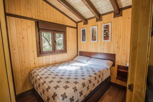 a bedroom with a bed in a wooden cabin at Complejo Residencial Los Enebros in Arroyo Frio