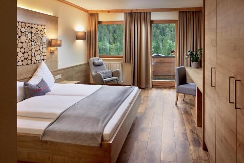 a hotel room with a large bed and two chairs at Hotel Central - das kleine Boutique Hotel am Achensee in Pertisau