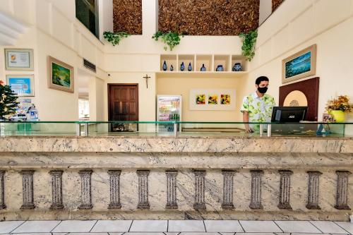 a man standing at a counter in a building at Yak Beach Hotel Ponta Negra in Natal