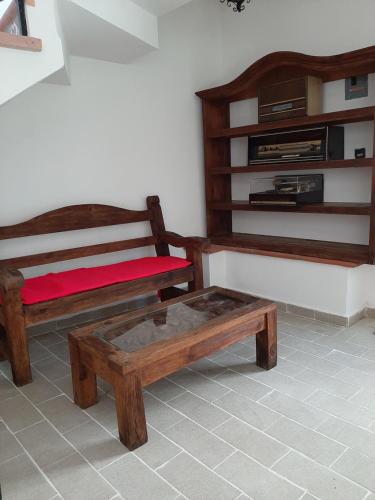 Habitación con 2 bancos de madera y mesa de centro. en Hotel Posada San Javier en Taxco de Alarcón