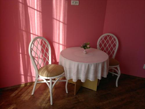 a table with two chairs and a vase of flowers on it at Vila Patricie in Luhačovice