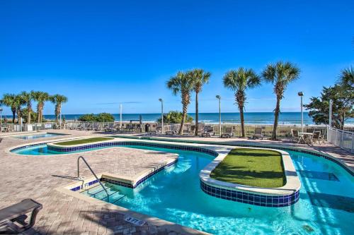 a swimming pool with palm trees and the beach at Myrtle Beachfront Bliss Pools, Views and SkyWheel! in Myrtle Beach