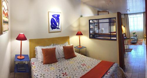 a bedroom with a bed and two lamps on tables at Taller de artista in Colonia del Sacramento