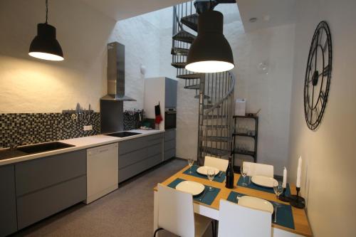 een keuken met een tafel en stoelen en een wenteltrap bij La Belle Etoile in Avon-les-Roches