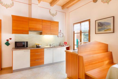 una cucina con armadi in legno e forno a microonde di Casa Nonni a Molveno