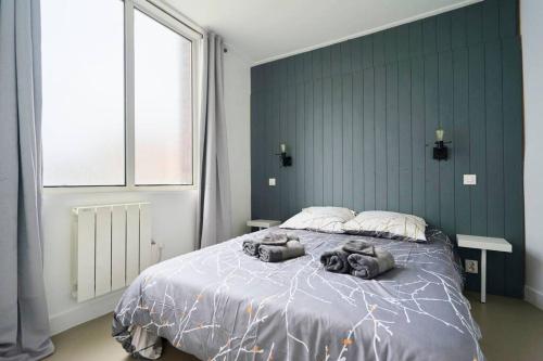 - une chambre dotée d'un grand lit avec 2 oreillers d'animal dans l'établissement LocationsTourcoing - Le Dron, à Tourcoing