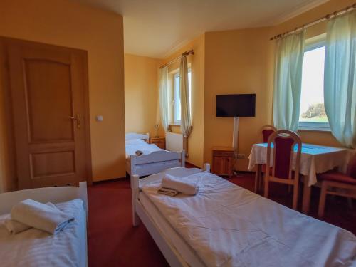 Habitación de hotel con 2 camas y TV en Hotelik Dworek, en Legnickie Pole