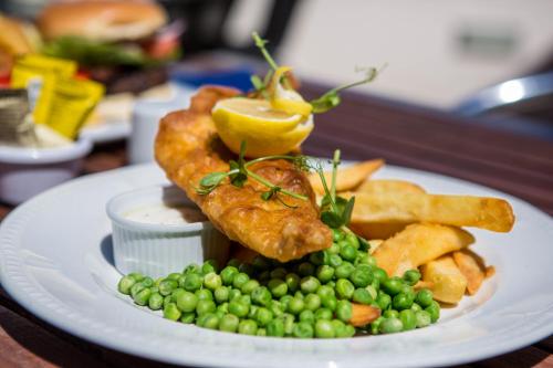 a plate of food with peas and fish and chips at Yelf's Hotel in Ryde