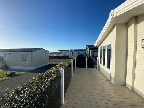 a wooden walkway next to a house at Sea view 3 bedroom Lodge in Porthcawl