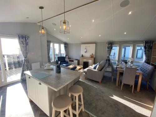a kitchen and living room with a table and chairs at Sea view 3 bedroom Lodge in Porthcawl