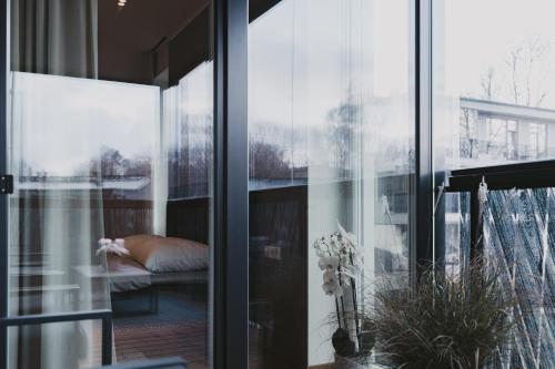 a glass door leading to a bedroom with a bed at ÖÖ Street Luxury Apartment with Terrace in Tartu