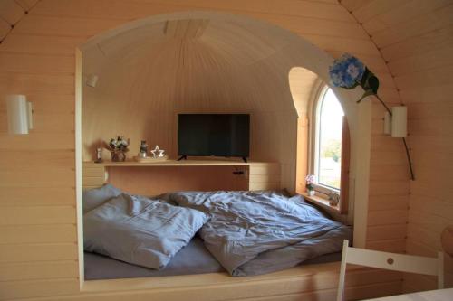 a room with a bed with a window and a tv at Schmidis Igluhuts im Pfaffenwinkel - Tiny House 2 in Apfeldorf