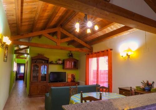 a kitchen and living room with a table and a tv at Casarural Vallecillo in Vallecillo