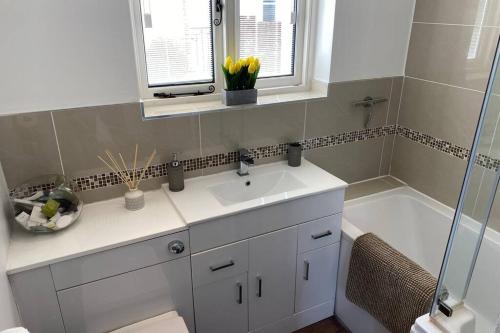 貝辛斯托克的住宿－Overton Annexe，浴室配有水槽、淋浴和浴缸。