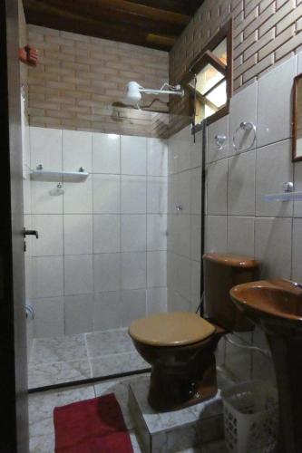 a bathroom with a toilet and a shower and a sink at Pousada Mar Azul in Trindade
