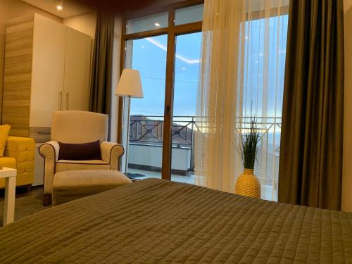 een slaapkamer met een bed, een stoel en een raam bij Milmari Mountain view - I11 in Kopaonik