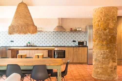 a kitchen with a wooden table and a dining room at La Pallissa Pals in Pals