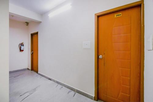 an empty hallway with a wooden door in a building at Orange Corner, Near Kempegowda Airport, Airport Pickup And Drop Available 24x7 in Bengaluru