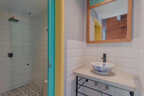 La salle de bains est pourvue d'un lavabo, d'un miroir et d'une douche. dans l'établissement Masaya Medellin, à Medellín